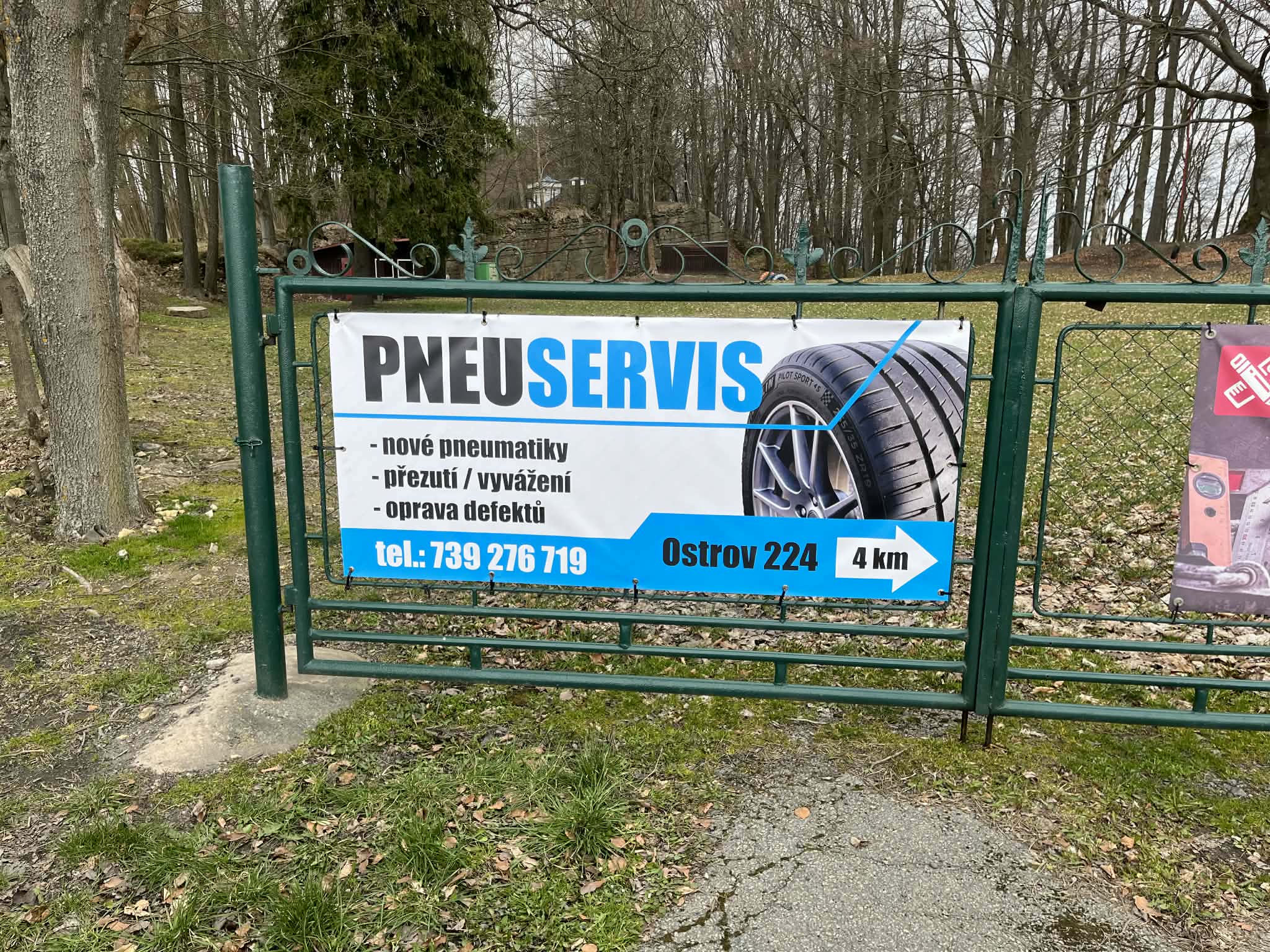 Označení pneuservisu u silnice v Ostrově